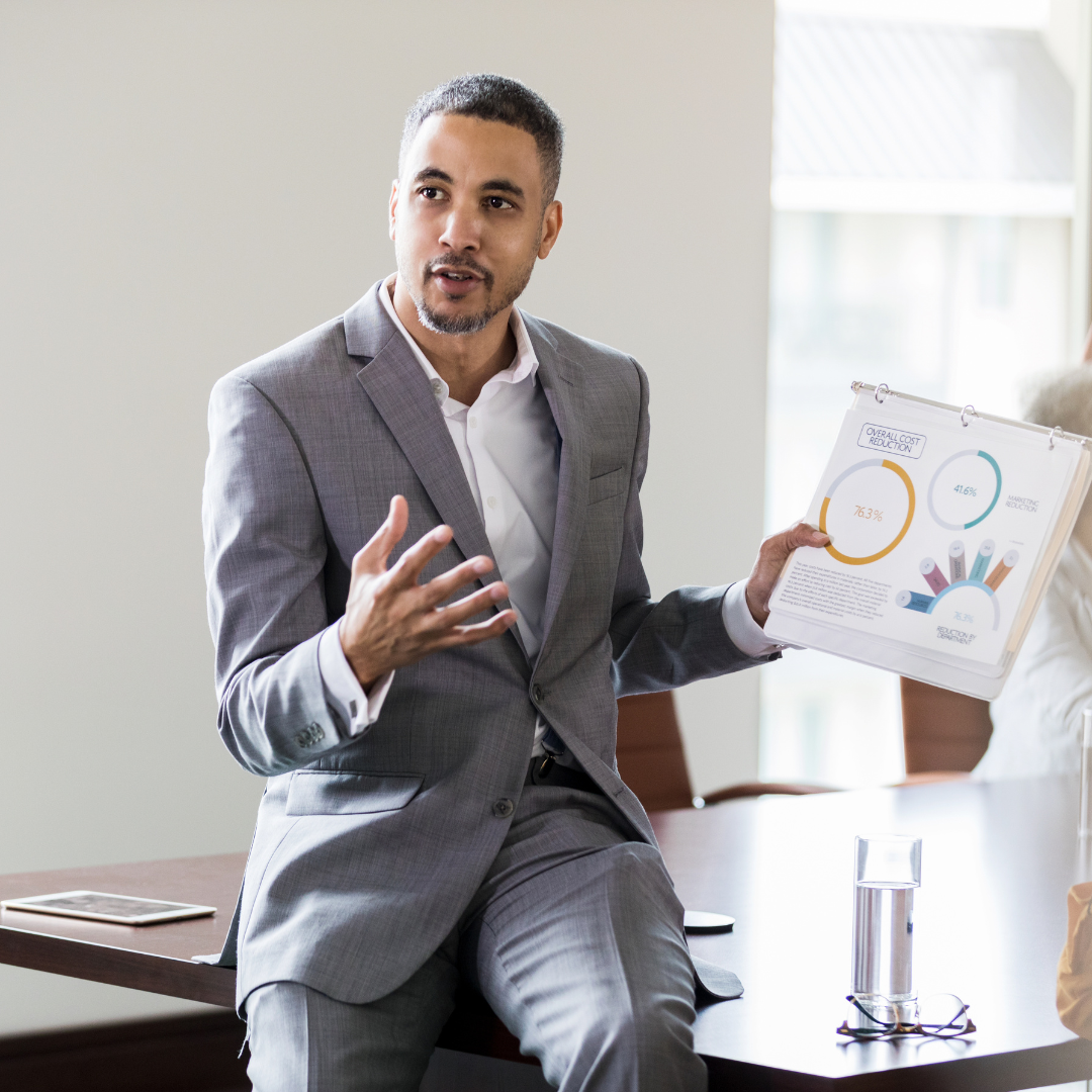 Man presenting paperwork | commercial real estate services in Indianapolis | Indianapolis commercial investment sales and advisory